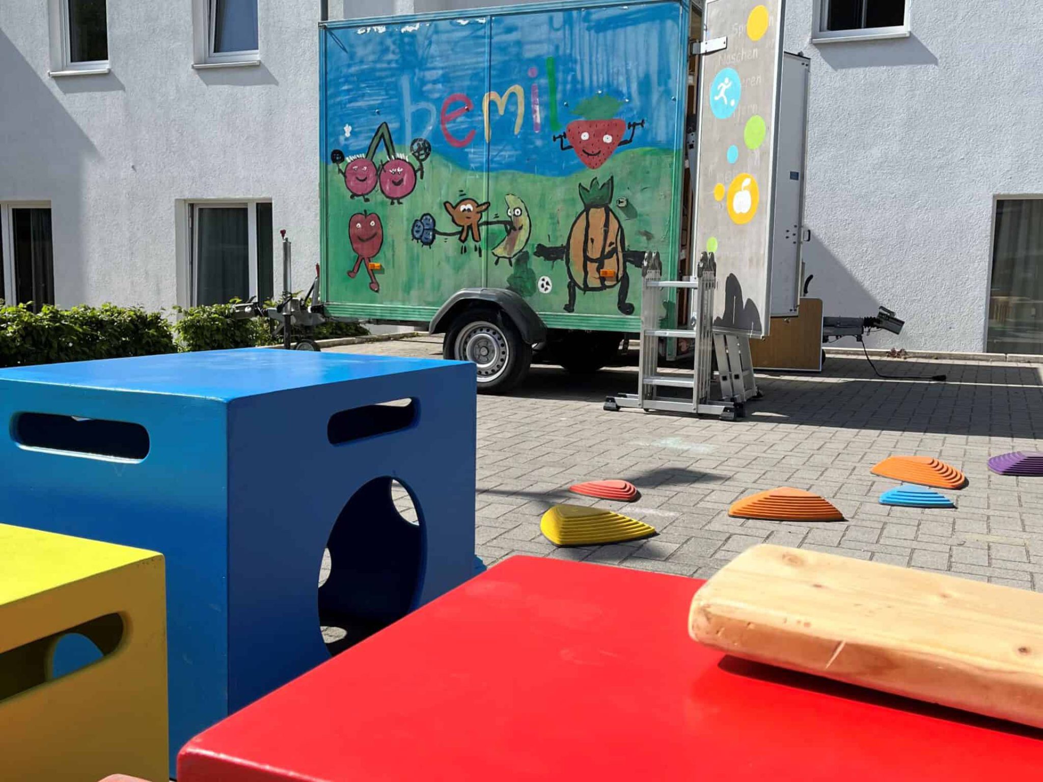 Kisten, Flussinseln und bemil Anhänger beim Übergangswohnheim.